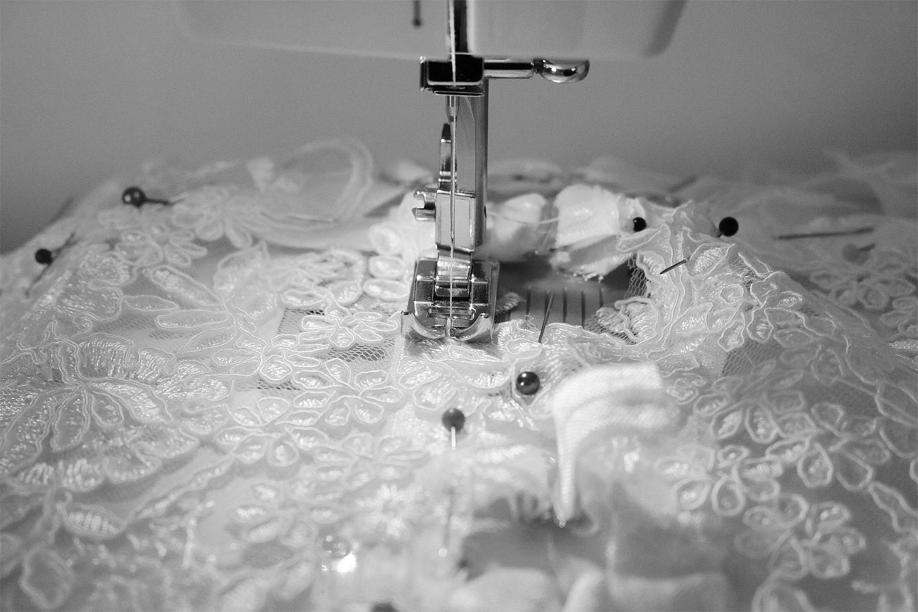 photo représentent l'atelier de couture avec l'eguille de la machine à coudre qui est entrein de coudre une lingerie broder
